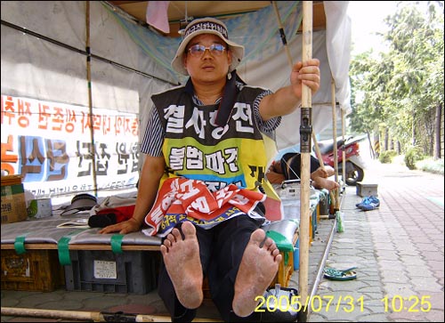 지난해 현대차 울산공장을 맨발로 한 바퀴 돈 뒤 대덕사 천막농성장에서 1인시위를 벌이고 있는 변창기씨. 